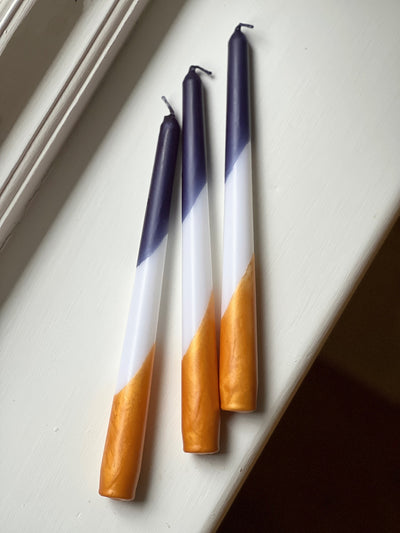 Dip dye taper candles in beautiful indigo blue and warm gold. 7 hours of candlelight from each dinner candle. Sold in sets of three. Made in England.